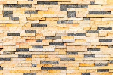 Multicolored brick wall texture pattern with stacked stone tiles.の写真素材