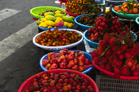 Vibrant tropical fruit market display with colorful exotic varieties in baskets.の写真素材