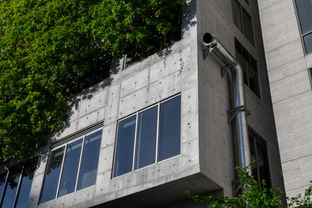 Modern green building with vertical garden and concrete facade.の写真素材