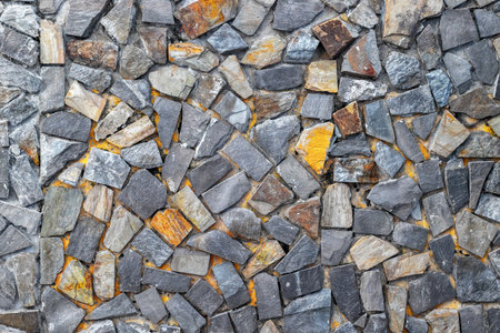 Stone wall texture with varied color and shape mosaic patterns.の写真素材