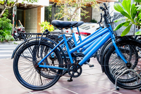 Row of blue bicycles parked on urban sidewalk outdoor transportation scene.の写真素材