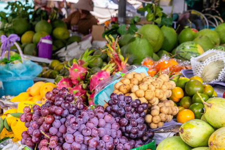 Colorful tropical fruit market display with grapes and exotic varieties.の写真素材