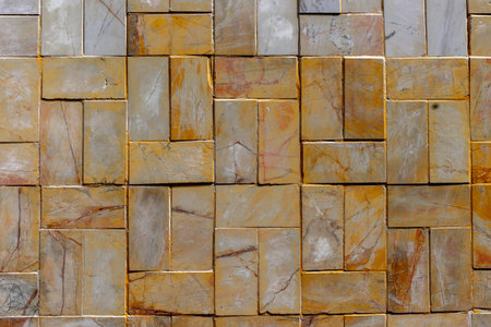 Natural stone wall texture with rectangular pattern in earthy tones.の写真素材
