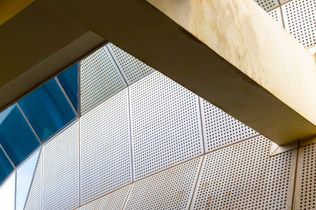 Modern architectural design featuring perforated white panels and geometric patterns.の写真素材