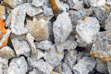 Close-up of gray concrete rubble pieces mixed with small orange fragments.の写真素材