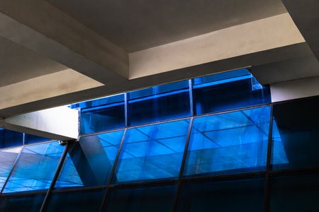 Modern architecture: blue glass facade with angular concrete elements.の写真素材