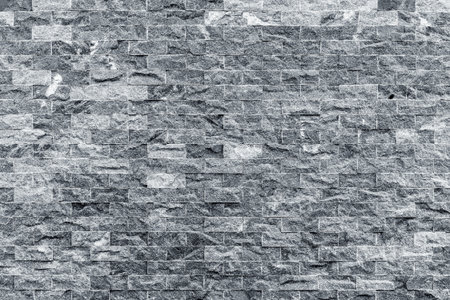 Gray brick wall pattern with textured stone surface in urban setting.の写真素材