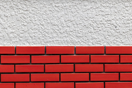 Red brick wall with textured white plaster background.の写真素材
