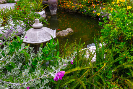 Serene japanese garden with stone lantern and vibrant foliage.の写真素材