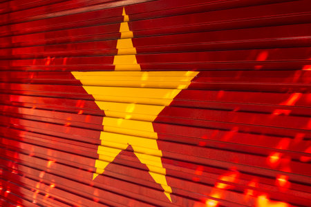 Yellow star on red metal door background with light reflections.の写真素材