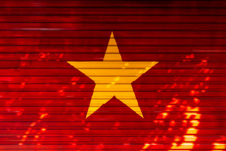 Vietnamese flag on red metal background with yellow star highlight.の写真素材