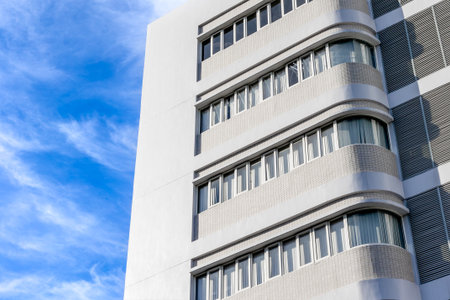 Modern architecture building with curved windows against blue sky.の写真素材