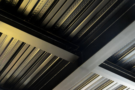 Close-up of industrial metal ceiling structure with beams and panels in modern architecture.