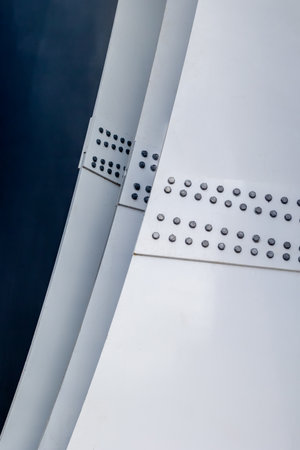 Modern architectural detail with riveted metal panels and abstract curves.