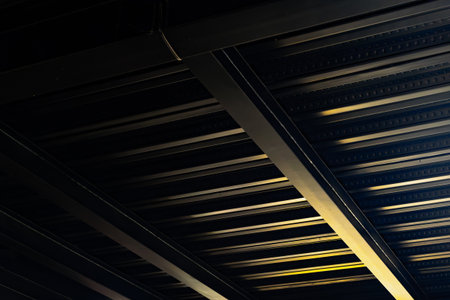 Industrial metal ceiling with geometric patterns and subtle lighting shadows.