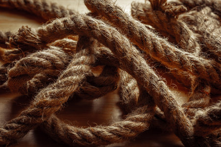 Close-up of coiled hemp ropes on wooden surface.