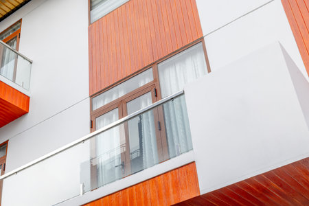 Modern architecture with wooden facade and glass balconies.