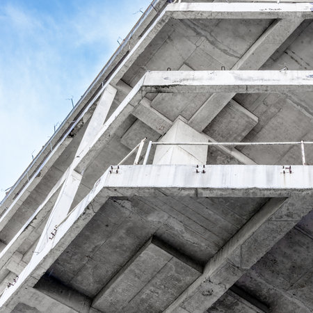 Modern concrete structure with geometric lines against a clear blue sky.の写真素材