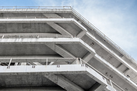 Abstract view of brutalist concrete architecture against blue sky.