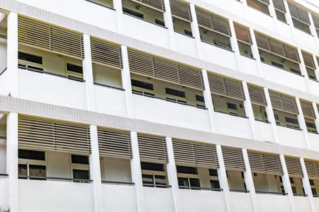 Modern white building exterior with horizontal louvers and windows.の写真素材