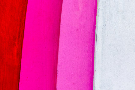 Abstract colorful wall with red, pink, and white vertical stripes.の写真素材