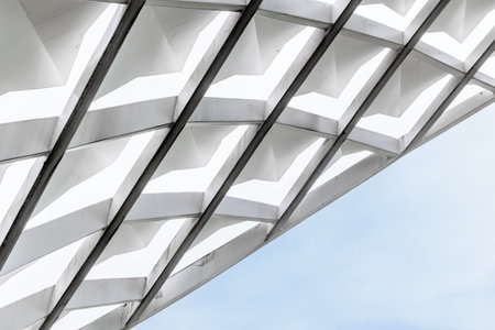 Modern geometric architecture with white structures against blue sky.