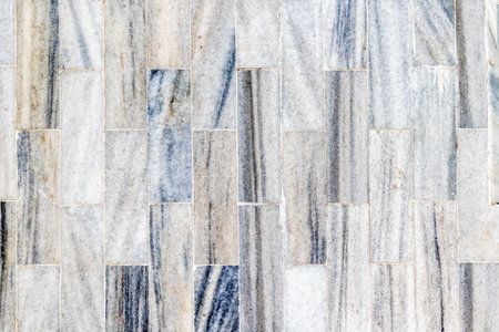 Texture of gray and white marble tile wall with varied patterns.の写真素材