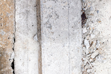 Rough textured concrete surface with cracks and weathered details.の写真素材