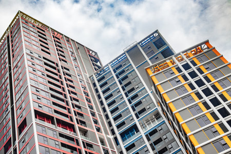 Modern urban architecture: colorful high-rise apartment buildings against cloudy sky.