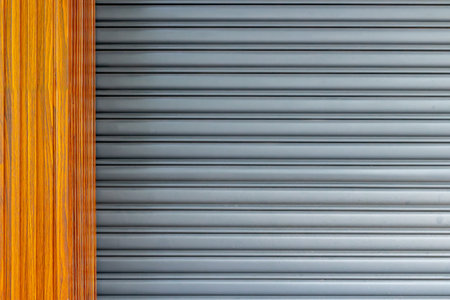 Modern metallic roller shutter door with wooden frame.
