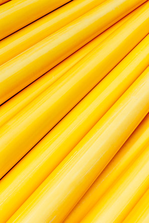 Bright yellow cylindrical pipes in a geometric pattern.の写真素材