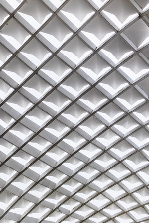 Abstract geometric ceiling with white repetitive diamond patterns in architectural design.の写真素材