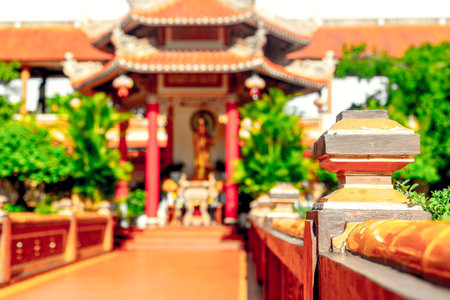 Vibrant Asian temple with red roof and decorative architecture in sunlight.の写真素材