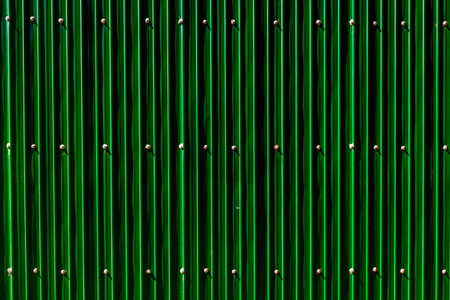 Green vertical metal fence with bolts patterned structure.の写真素材