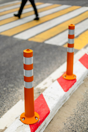 Pedestrian crossing with orange safety cones on urban road.の写真素材