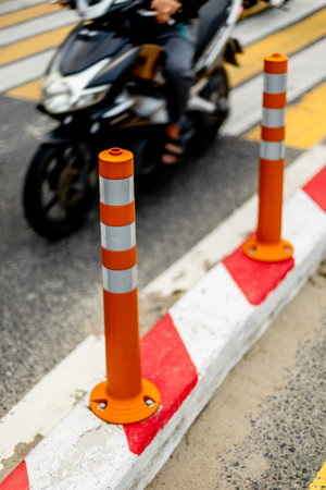 Traffic cones and motorcycle on crosswalk in urban street setting.の写真素材