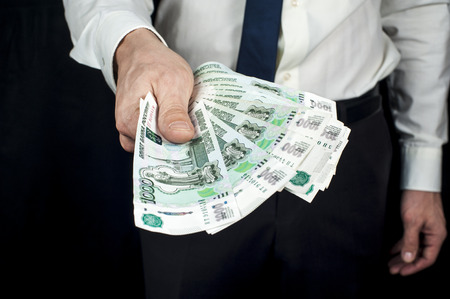 Businessman in skirt holds russian rubles banknotes. Financial theme. Horizontal view.の写真素材