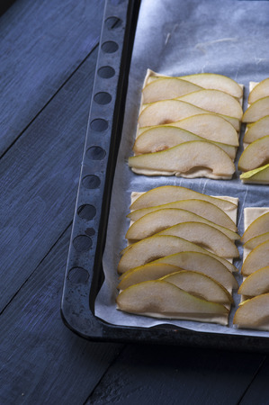 Puff pastry with pear slices on baking panの写真素材