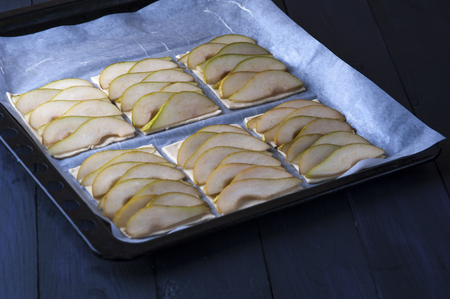 Puff pastry with pear slices on baking panの写真素材
