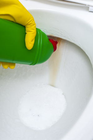 Green bottle with detergent on the background of toilet. Cleaning concept.の写真素材