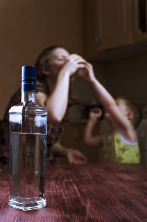 Child asks mother stop drinking. Family problems, alcoholic addiction. Focus on bottle.の写真素材