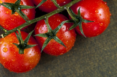 Ripe cherry tomatoes with water drops on brown napkinの写真素材
