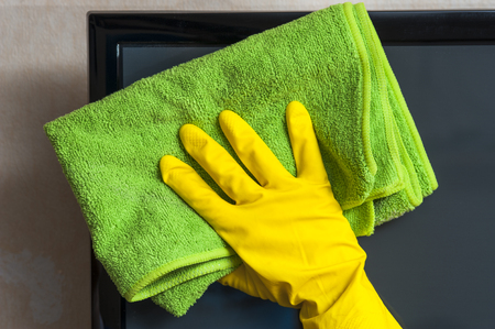 Closeup of female hand cleaning tv screenの写真素材