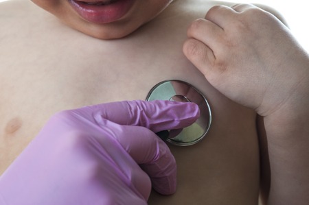 Pediatric doctor examining little baby boy with stethoscope isolated on white backgroundの写真素材