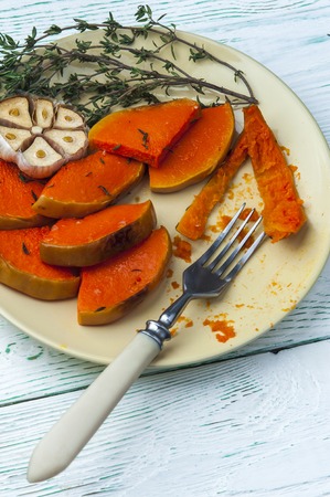 Pieces of baked pumpkin on yellow plate with fork. Vegetarian food.の写真素材