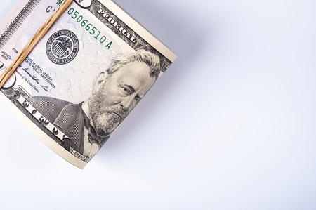 Fifty dollar bills in stack with rubberband on white background.の写真素材