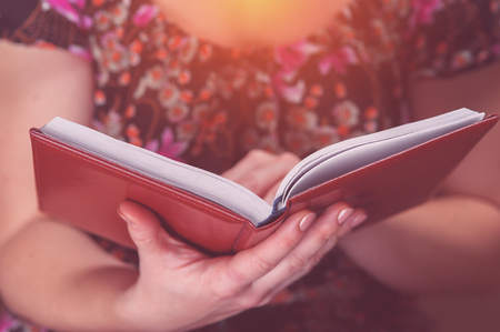 Cropped shot of young woman reading a book or diaryの写真素材