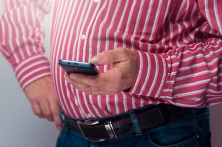 Cropped shot of senior confident man checking his smartphone.の写真素材