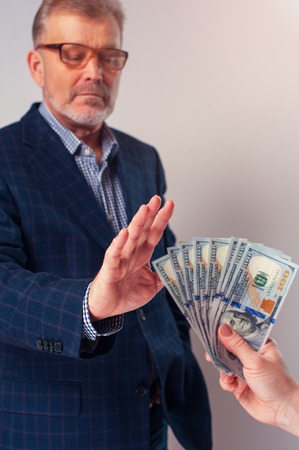 Portrait of senior businessman or manager rejecting bribe from partner. Bribery and corruption concept.の写真素材