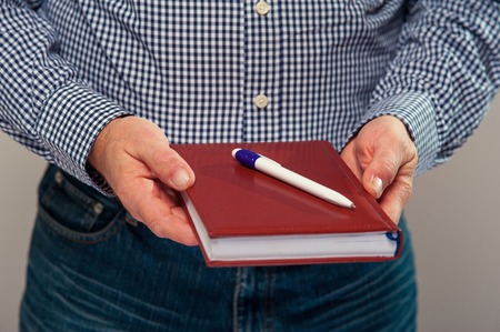 Cropped shot of senior male hands with diary and pen.の写真素材